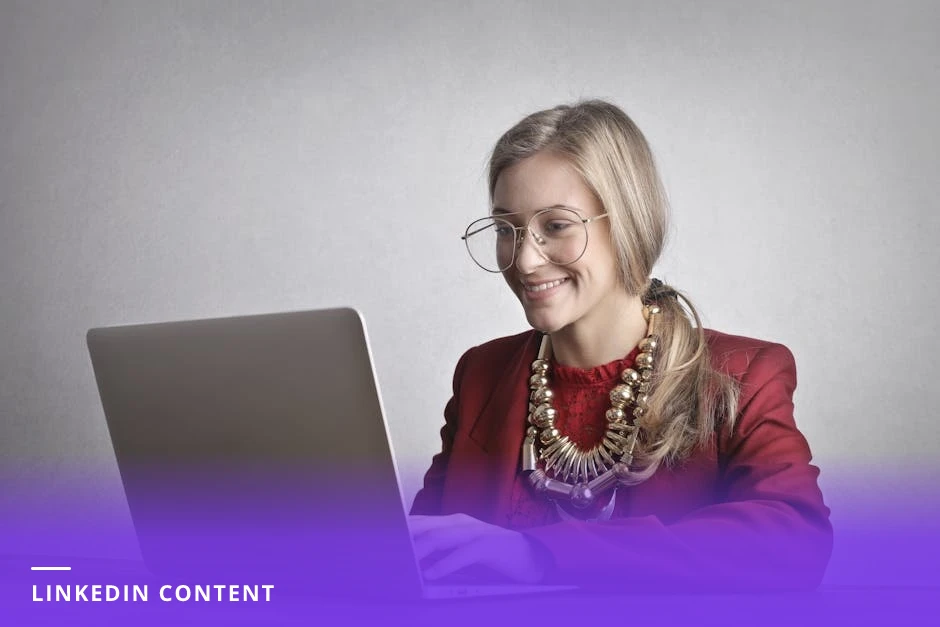 Female coach at a bright Scandinavian-style office desk typing a LinkedIn post on a laptop, notebook and coffee cup beside her, natural window light