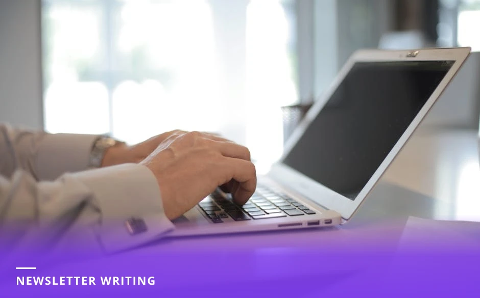 Mid-30s coach seated at a bright desk typing on a laptop, notebook and coffee nearby, bright Scandinavian-style office window light