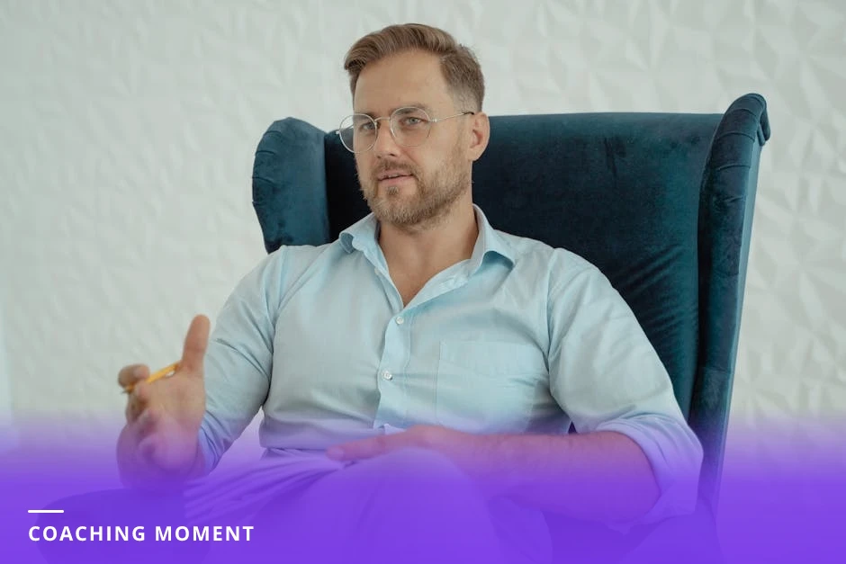 Coach attentively listening to a client across a small table, holding a notepad; bright Scandinavian office with natural light and candid, conversational mood.