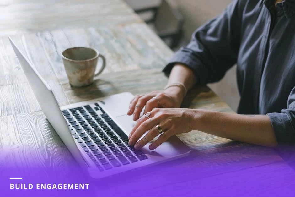 Diverse professional woman typing on a laptop at a bright modern Western office desk, LinkedIn post composer visible on the screen