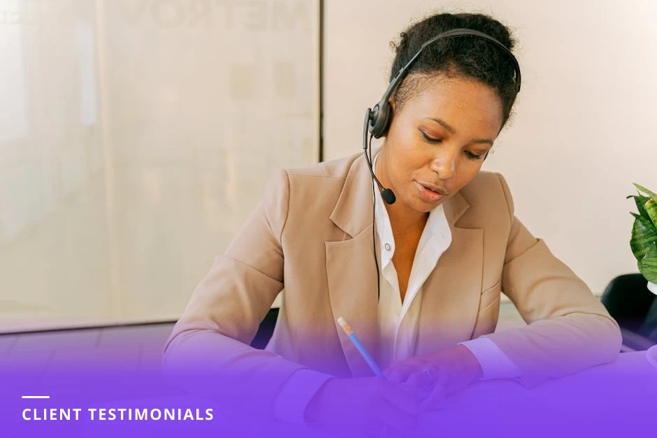 Diverse coach listening attentively while a client takes notes at a bright Scandinavian office table with a laptop and notepad visible