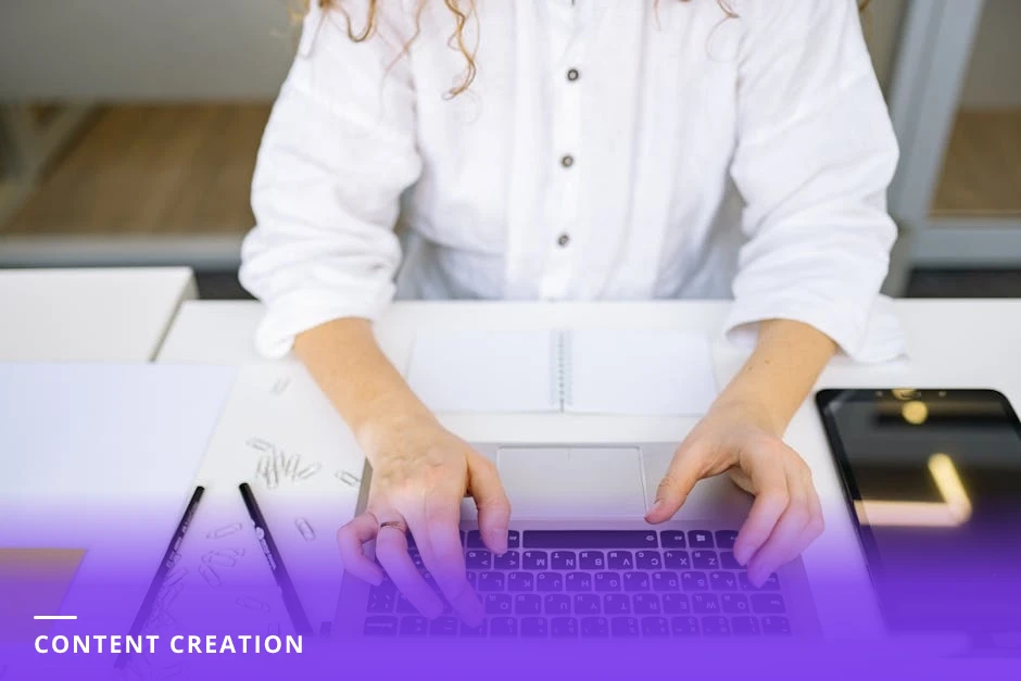 Professional woman typing on a laptop at a bright Scandinavian-style workspace, notebook and coffee beside her as she drafts a LinkedIn post