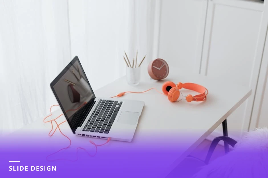 Coach at a bright Scandinavian-style desk working on a laptop showing slide layouts, notebook, pen, and coffee beside them, natural light from a window
